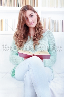 Portrait of confused lovely woman reading a book