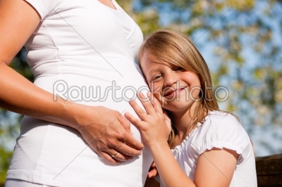 pregnancy - girl touching belly of pregnant mother