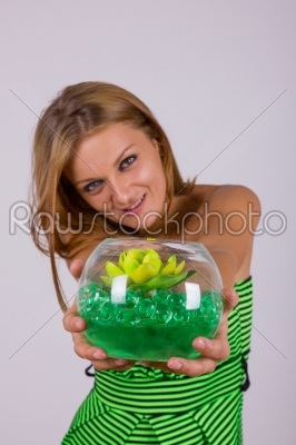 pretty woman holding gift with flower in glass bowl