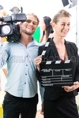 Production team with camera and take clap on film set or studio