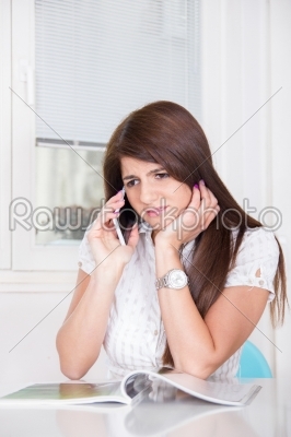 sad girl talking on the phone at home