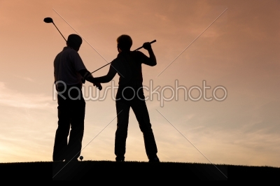 Senior couple playing Golf at sunset