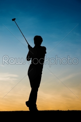 Senior female golf player at sunset
