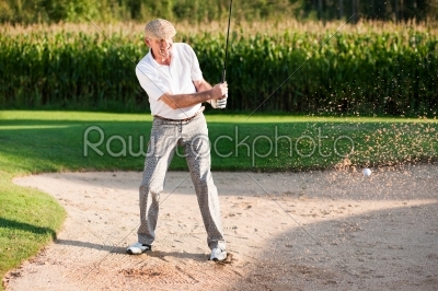 Senior golf player in sand trap