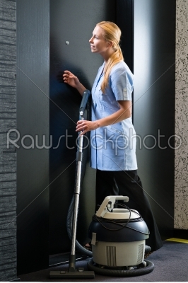 Service in hotel, maid with vacuum cleaner