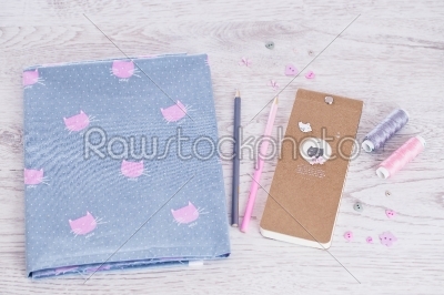 sewing materials, pencils, notes, fabric on a blue and pink color