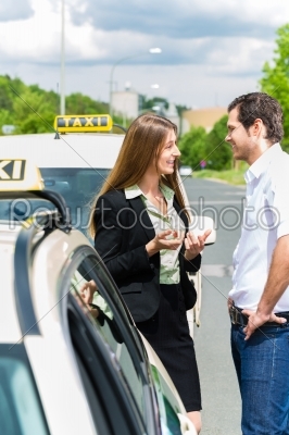 Taxi driver and passenger in front of car