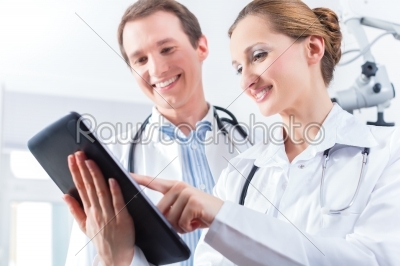 Team of doctors in clinic with tablet computer