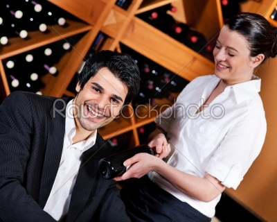 Waitress in restaurant offering red wine