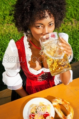 Woman in Dirndl drinking beer