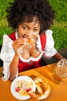 Woman in Dirndl drinking beer