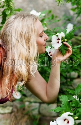 Woman in garden sniffing at flowers
