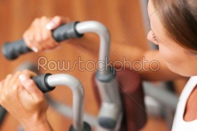 Woman in gym on machine exercising