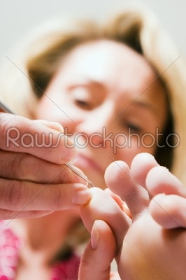 Woman practicing chiropody taking care of a feet
