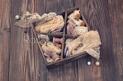 Wooden box with laces, ribbons and threads