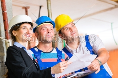 Work Team on construction site controlling floor plan