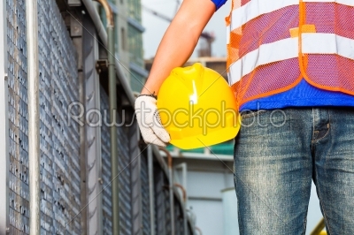 Worker on construction site with helmet or hard hat