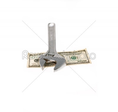 wrench and dollar bill isolated on white