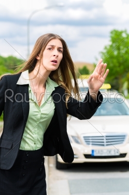 Young businesswoman calls for a taxi