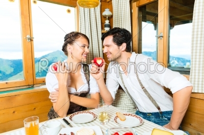 Young couple in mountain chalet eating
