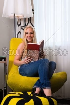 Young woman reading a book in hotel room